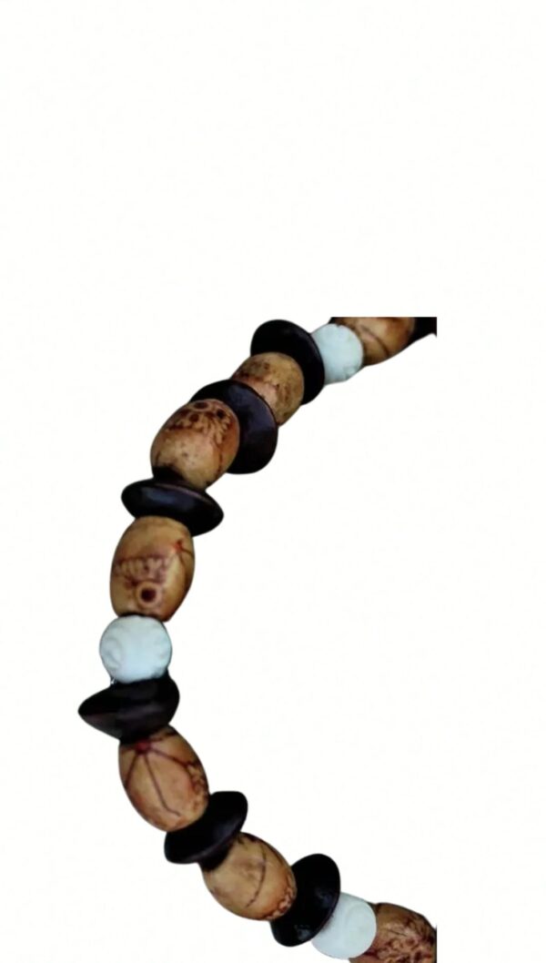 The Bonnie is a string of beads with white, brown, and black decorative elements arranged on a curved strand set against a plain background.